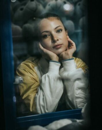 woman wearing white and yellow jacket taking a selfie screengrab